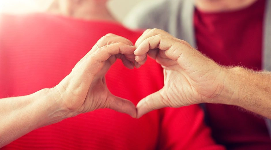 Two hands forming a heart shape together.