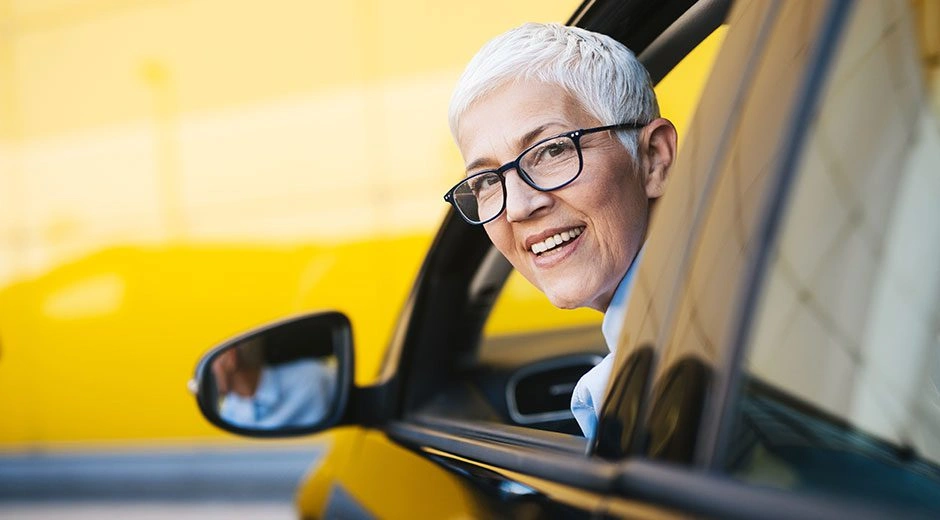 Smiling older adult in a car