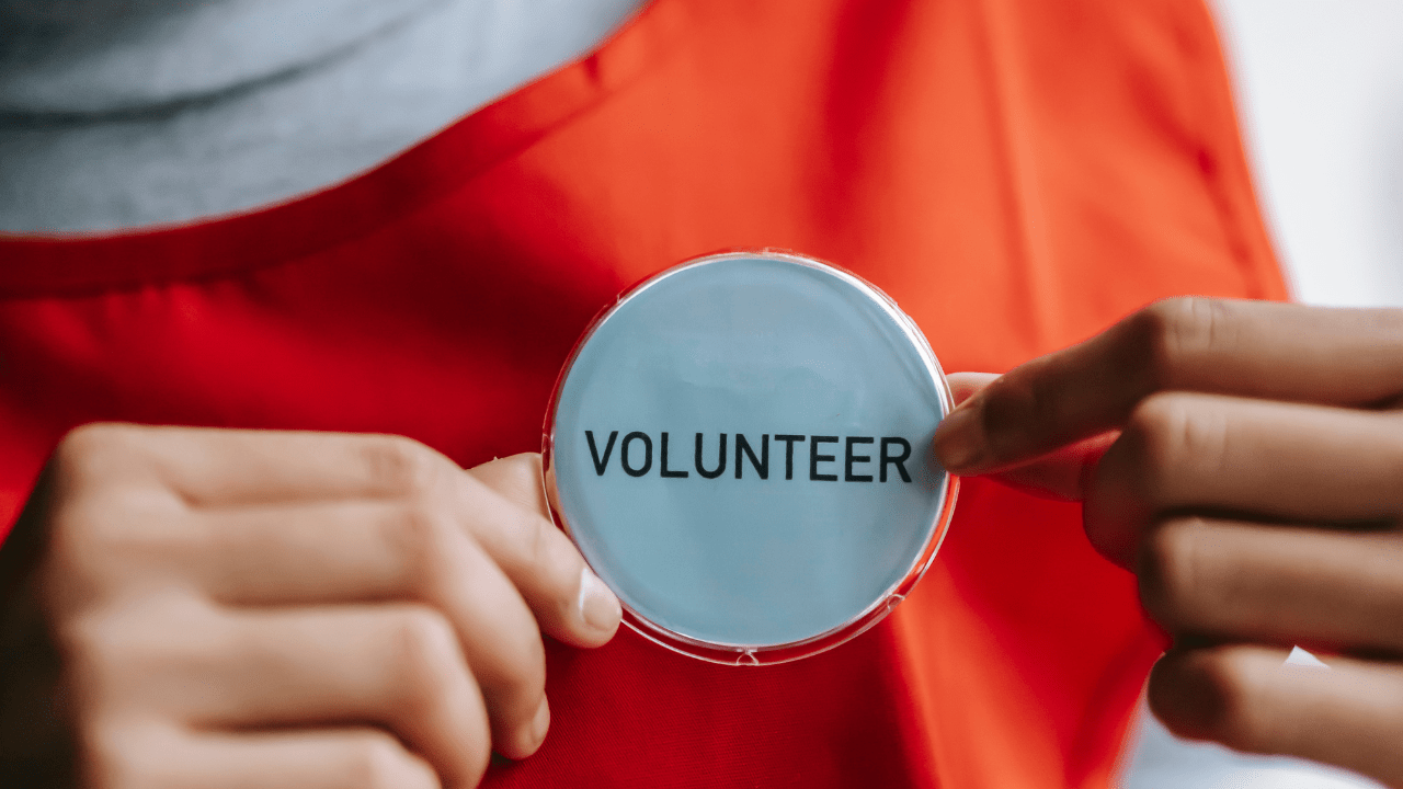 Volunteer wearing a badge with text.