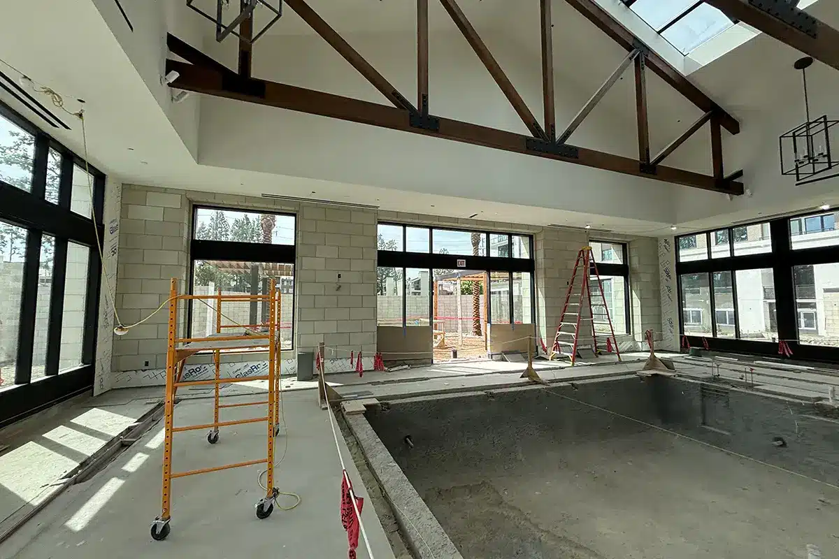 Under construction interior space with scaffolding and ladders.