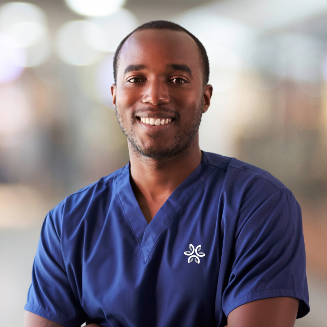 Male staff member in scrubs smiling