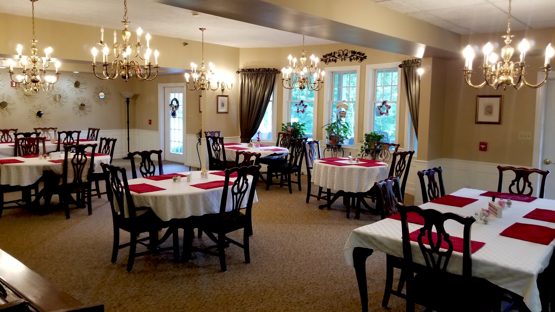 Elegant dining room setting with tables and chandeliers.