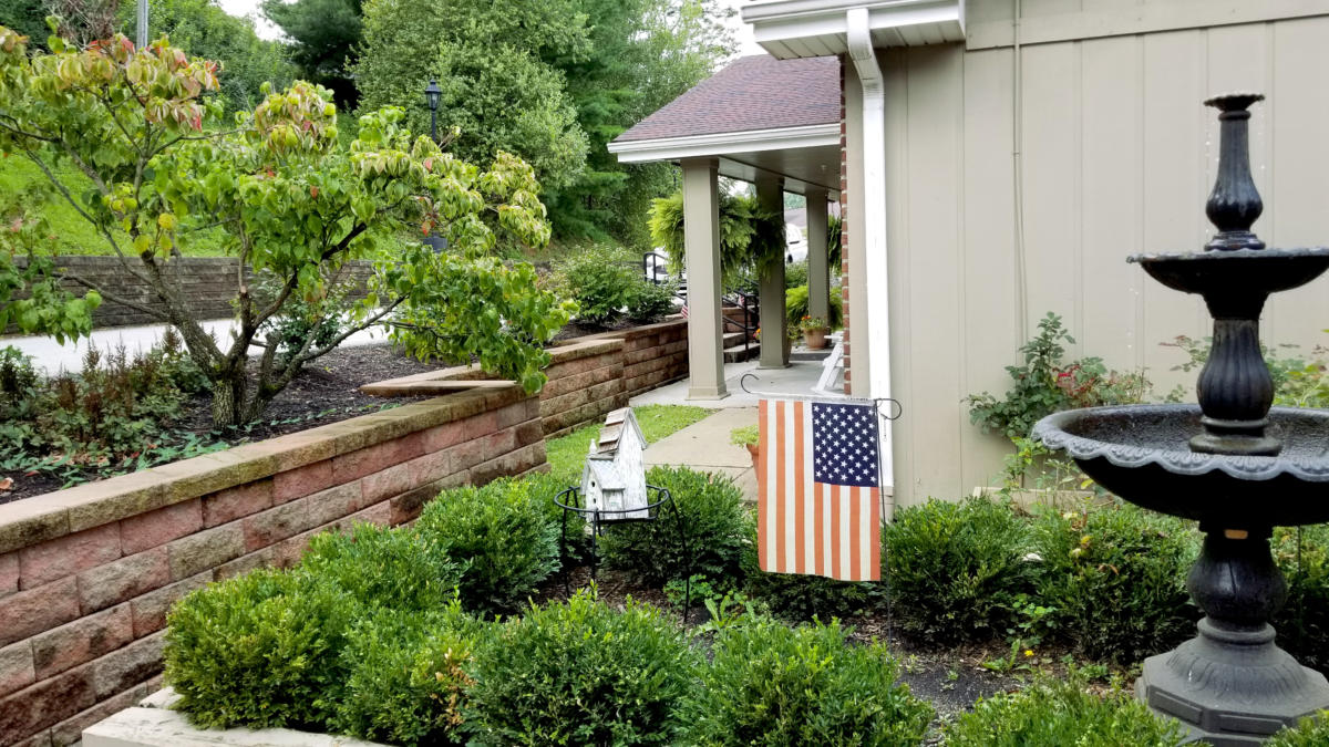Outdoor view of the facility with garden and American flag.