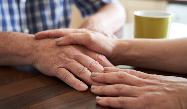 Two hands holding gently on a table