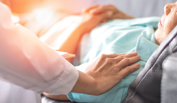 Caregiver comforting a patient in a care setting.