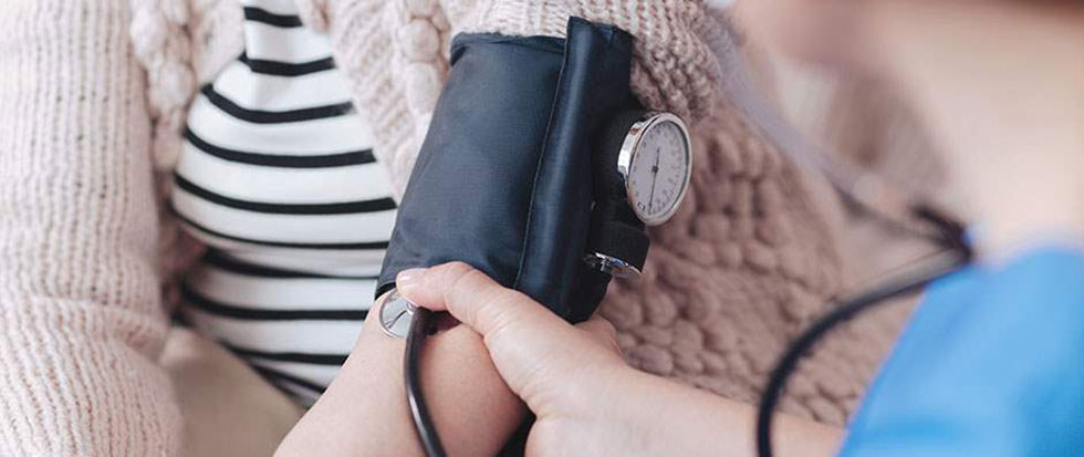 Healthcare professional taking blood pressure.
