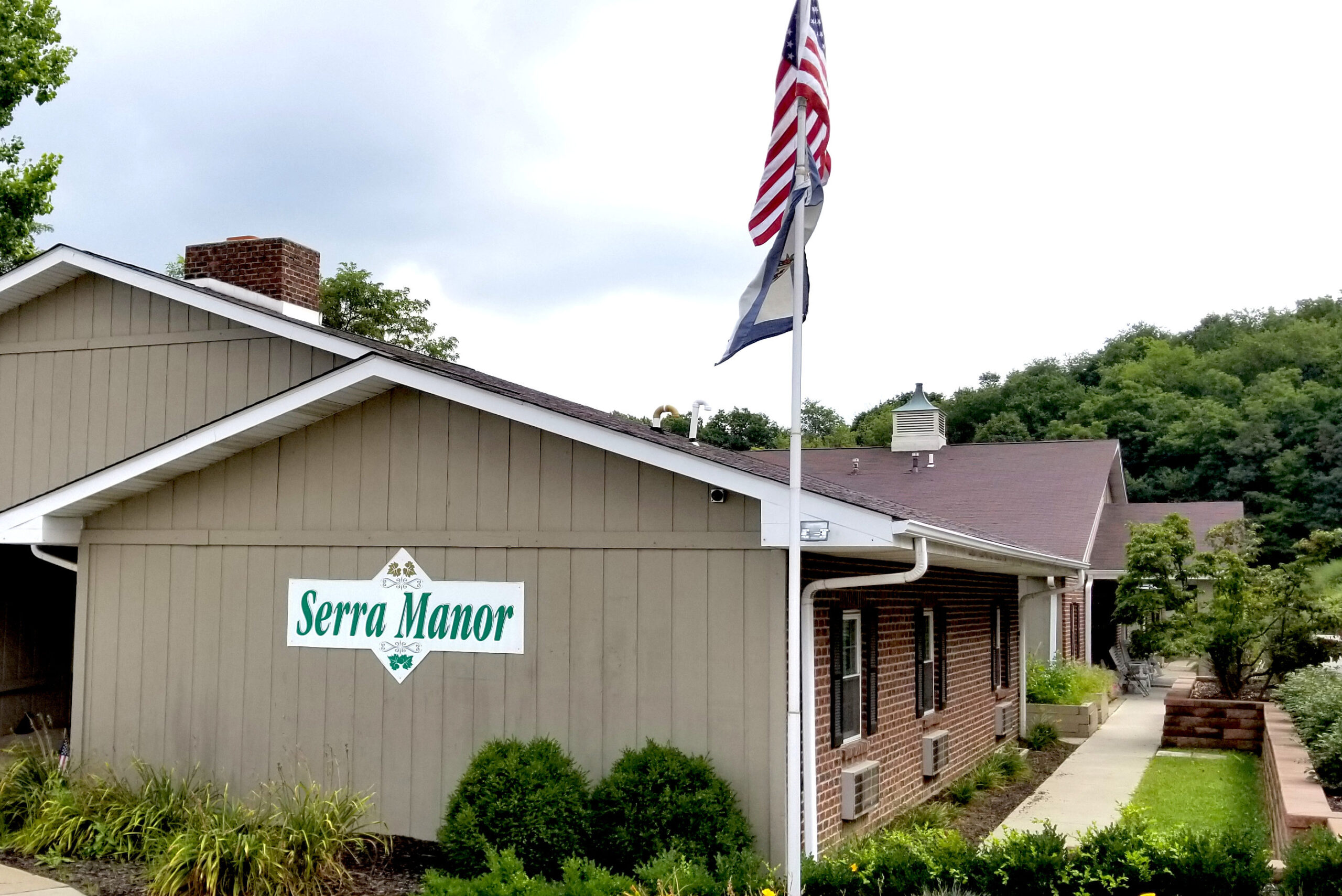 Exterior view of Serra Manor with flag.