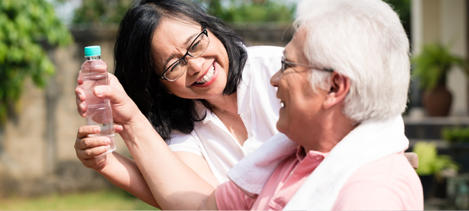 Caregiver assisting elderly man outdoors