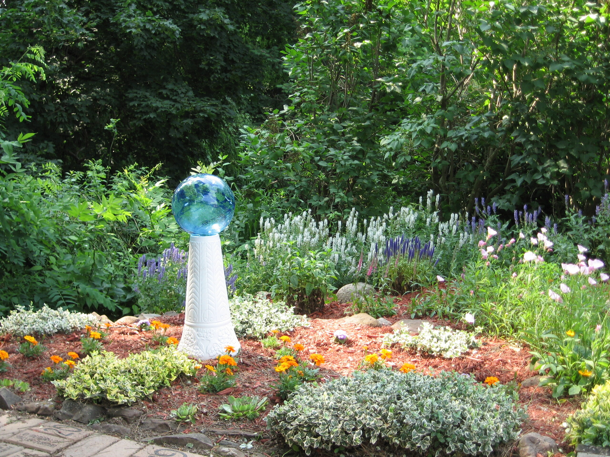 Vibrant garden with flowers and a decorative globe