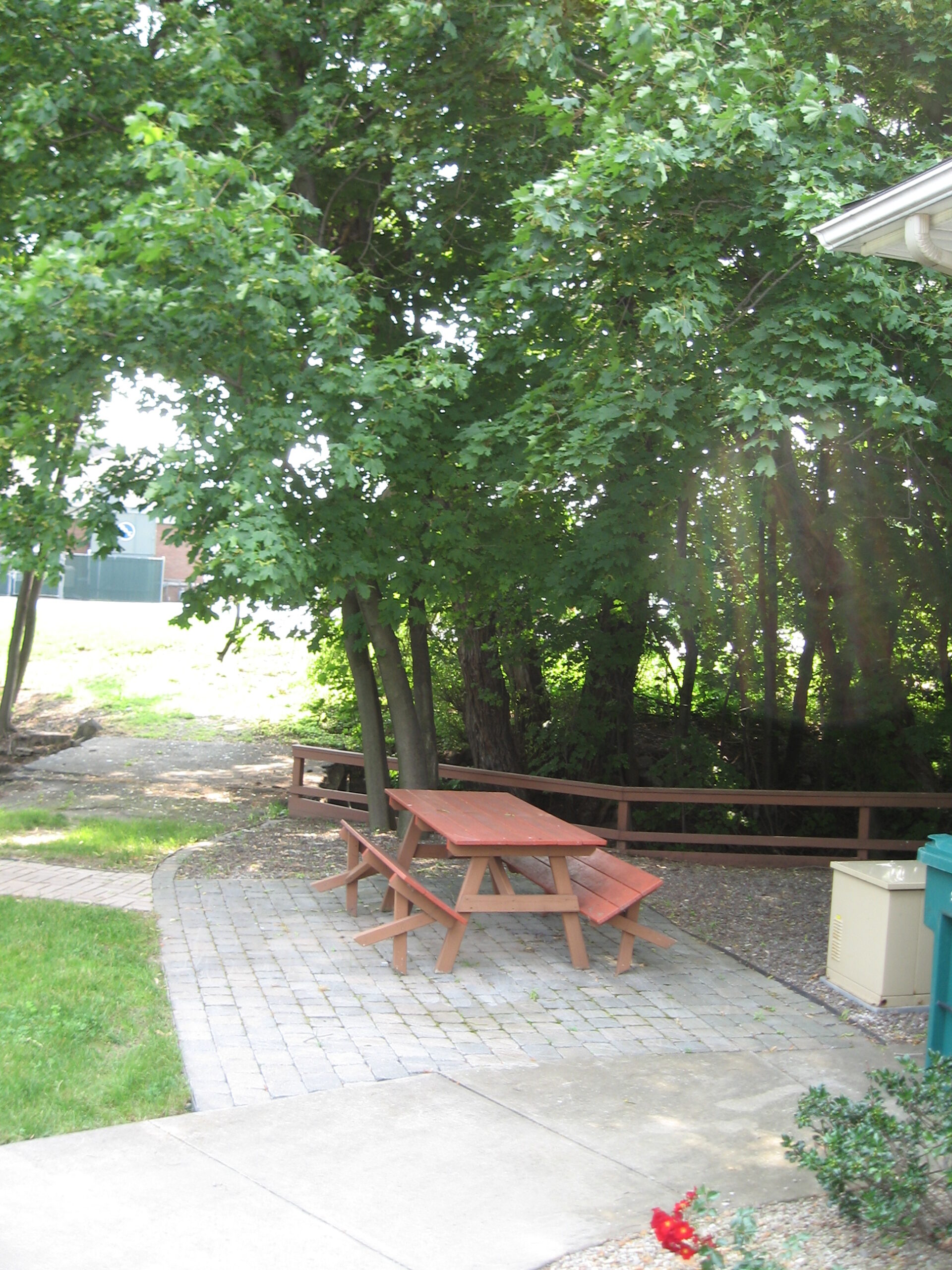 Outdoor seating area with picnic table and trees.