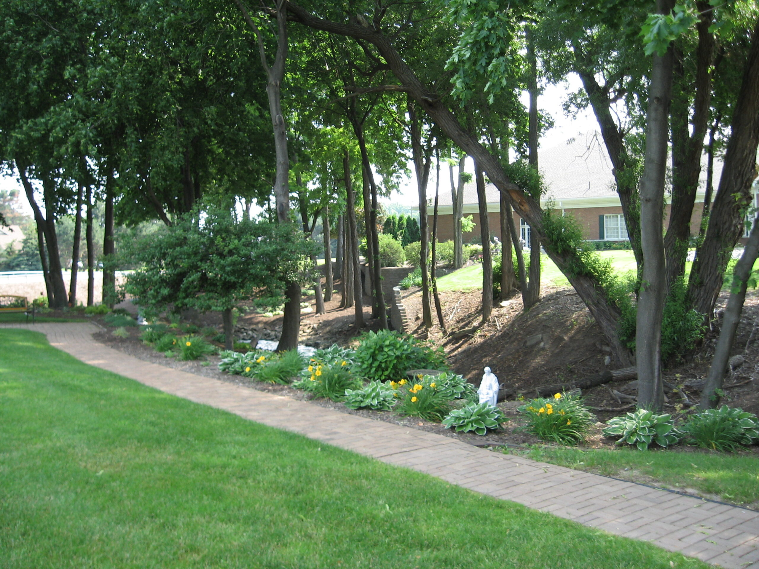 Pathway through greenery with flowers and trees