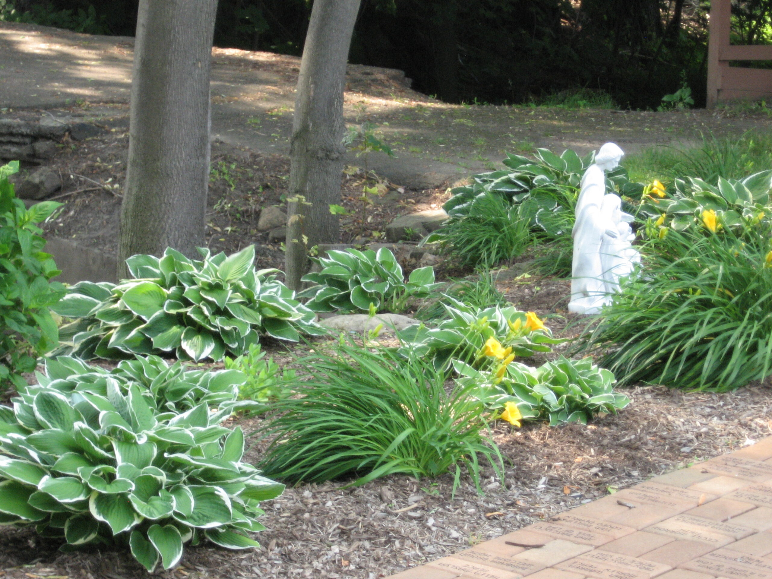 Garden area with plants and a statue.