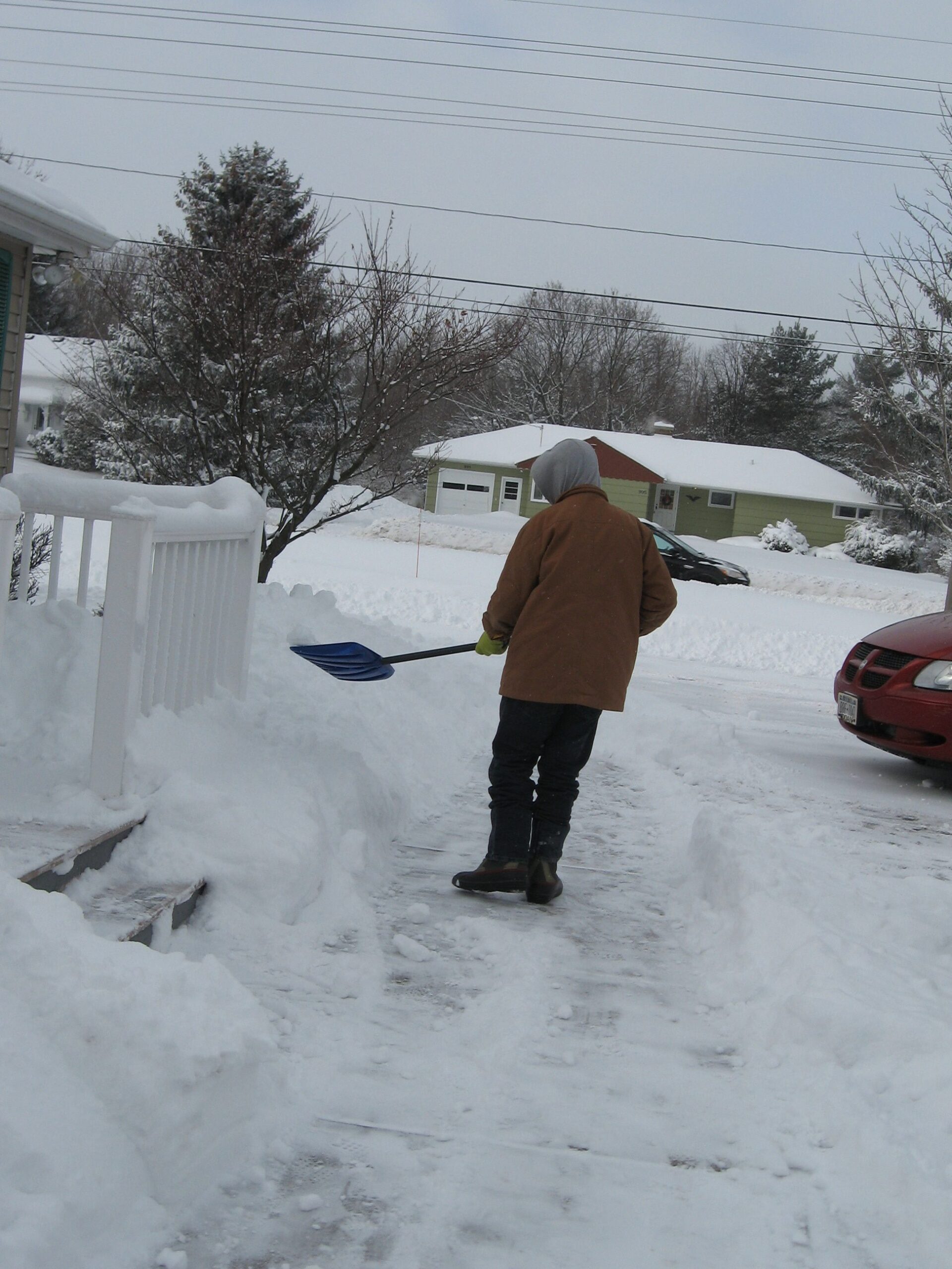 Person shoveling snow in a residential area