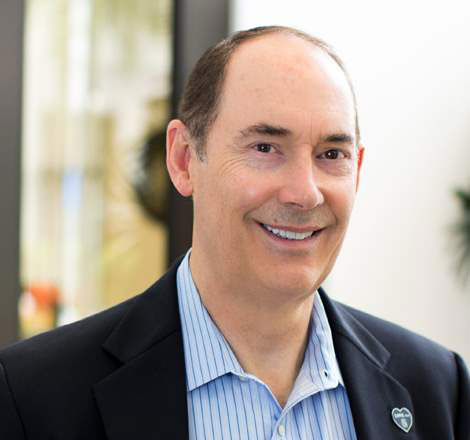 Smiling man in a suit with a pin