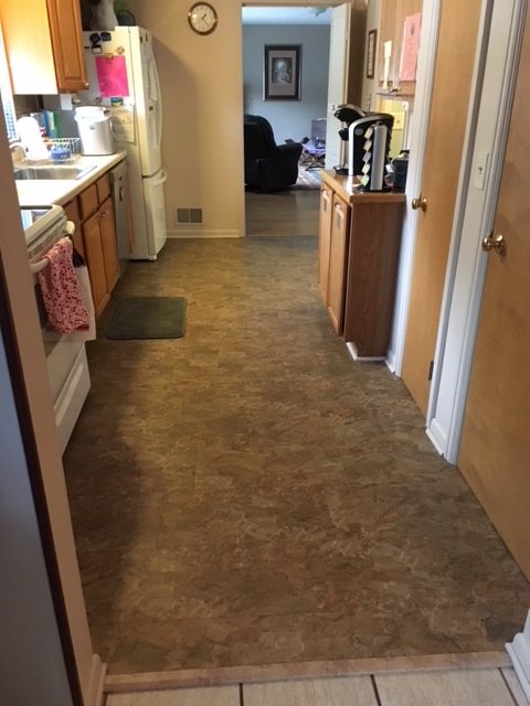 Narrow hallway leading to a kitchen area