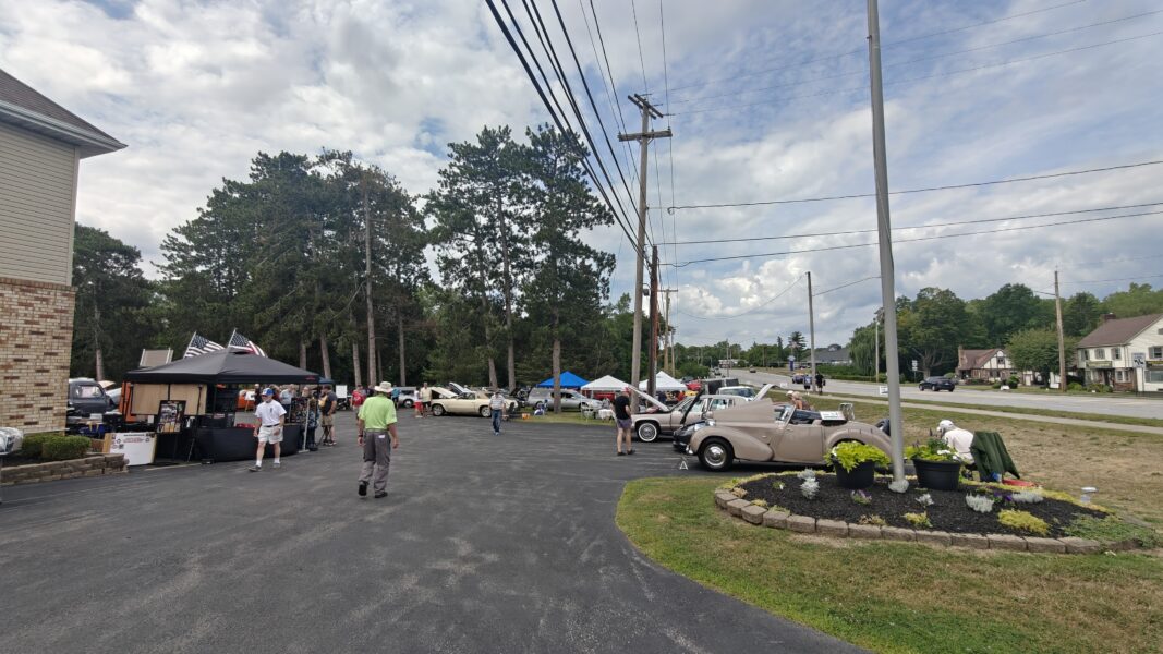 Outdoor community event with cars and people