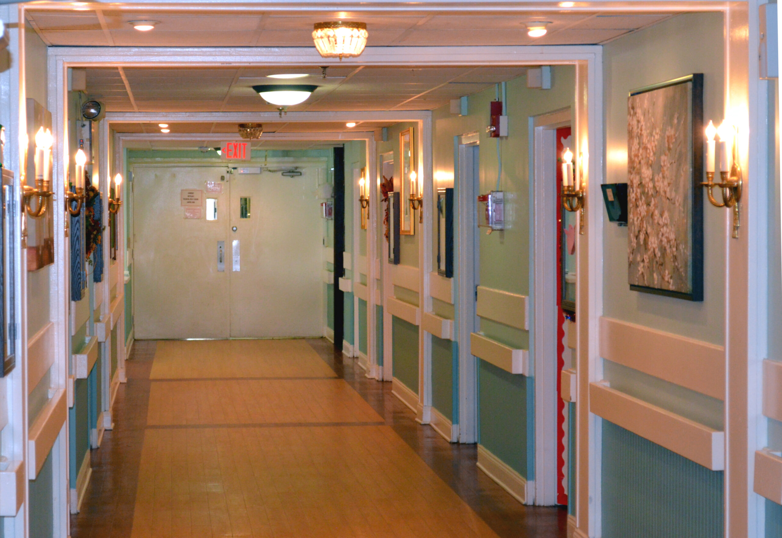 Interior hallway with wall sconces and artwork