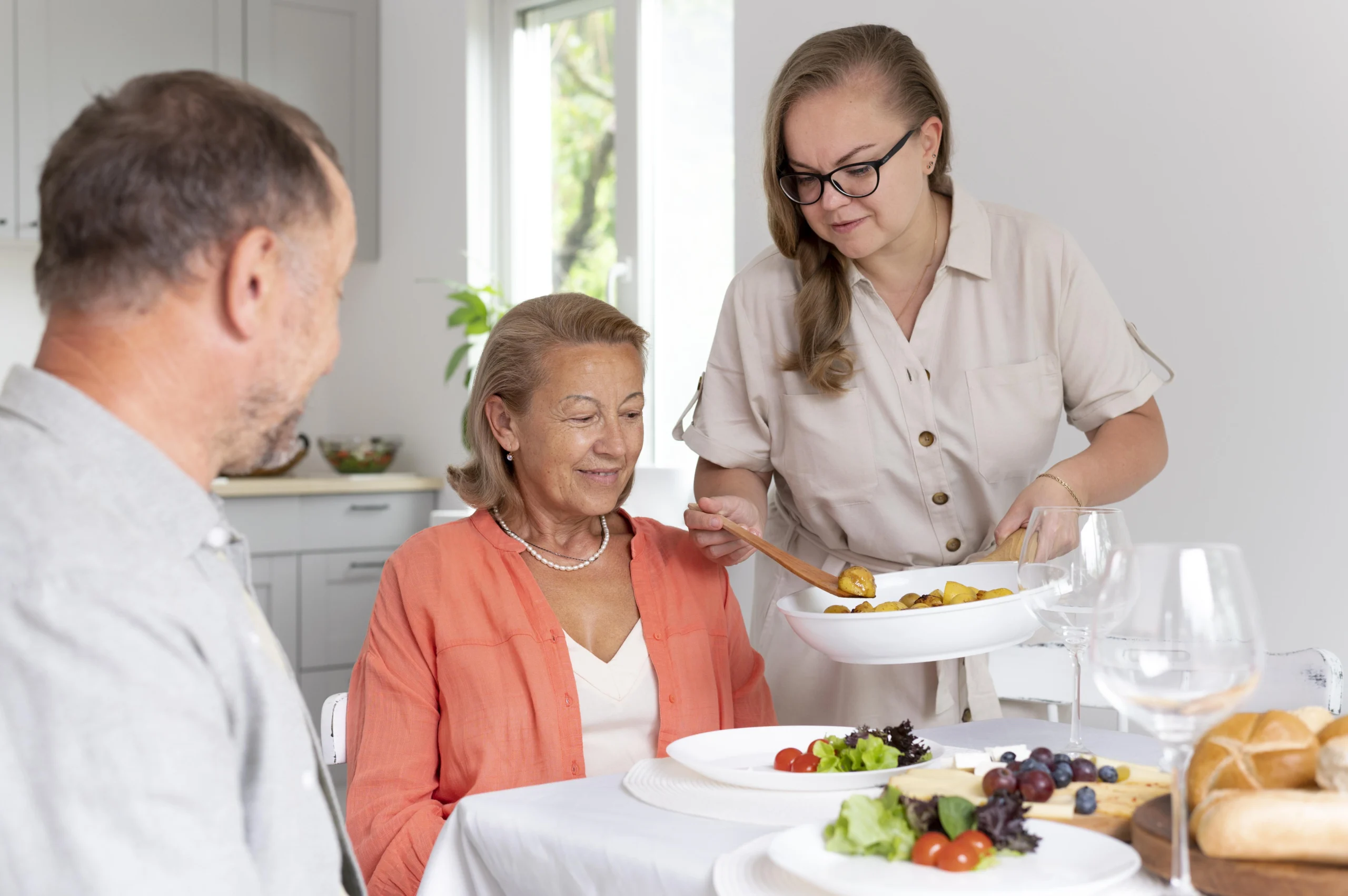 Resident enjoying a meal with staff assistance