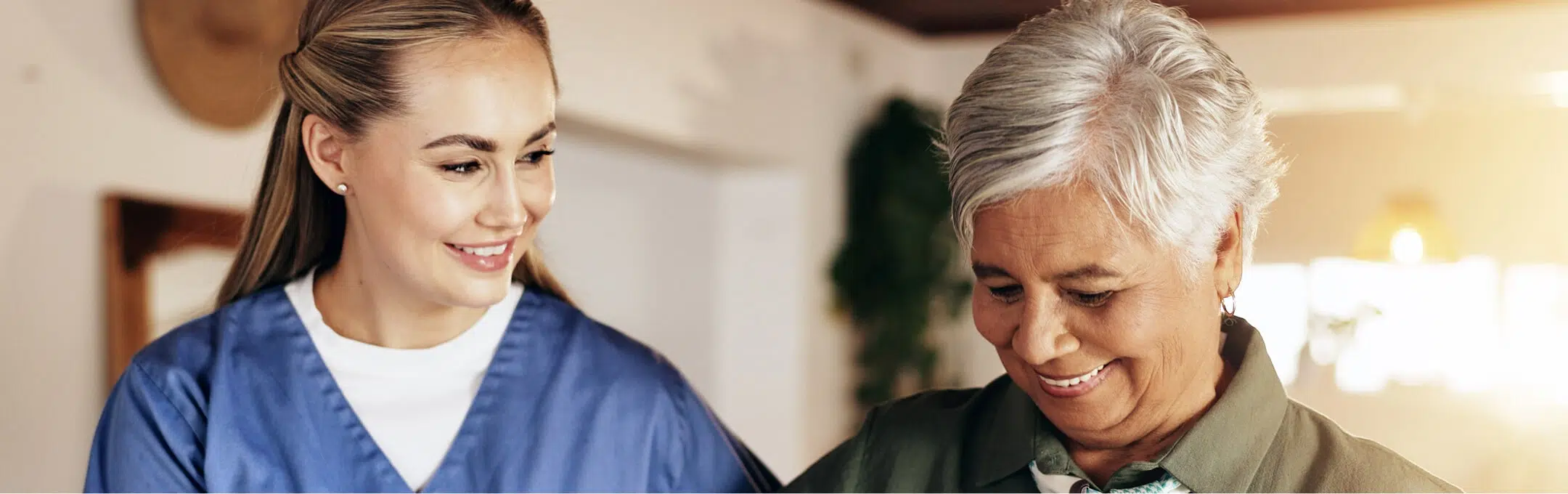 Caregiver assisting a senior resident in a bright activity area