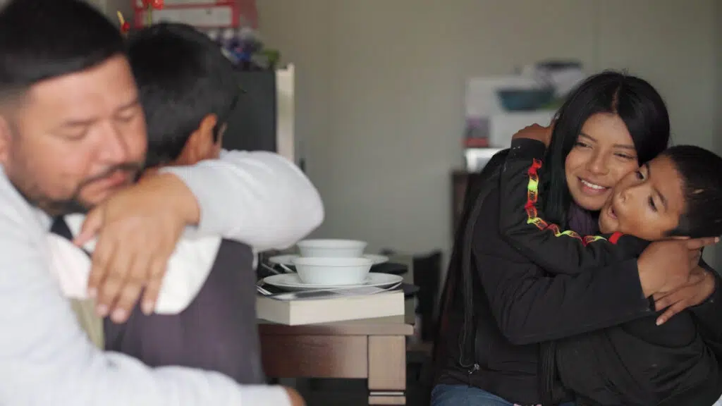 Family members hugging inside a residence