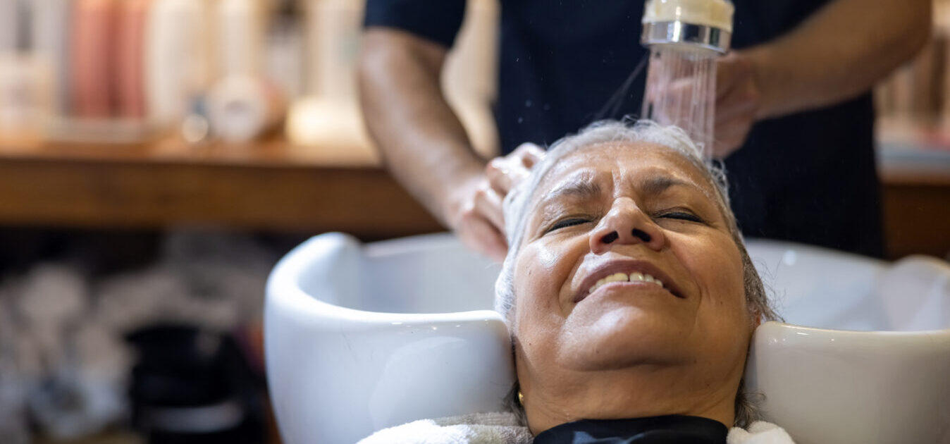 A resident receiving a hair wash in a salon