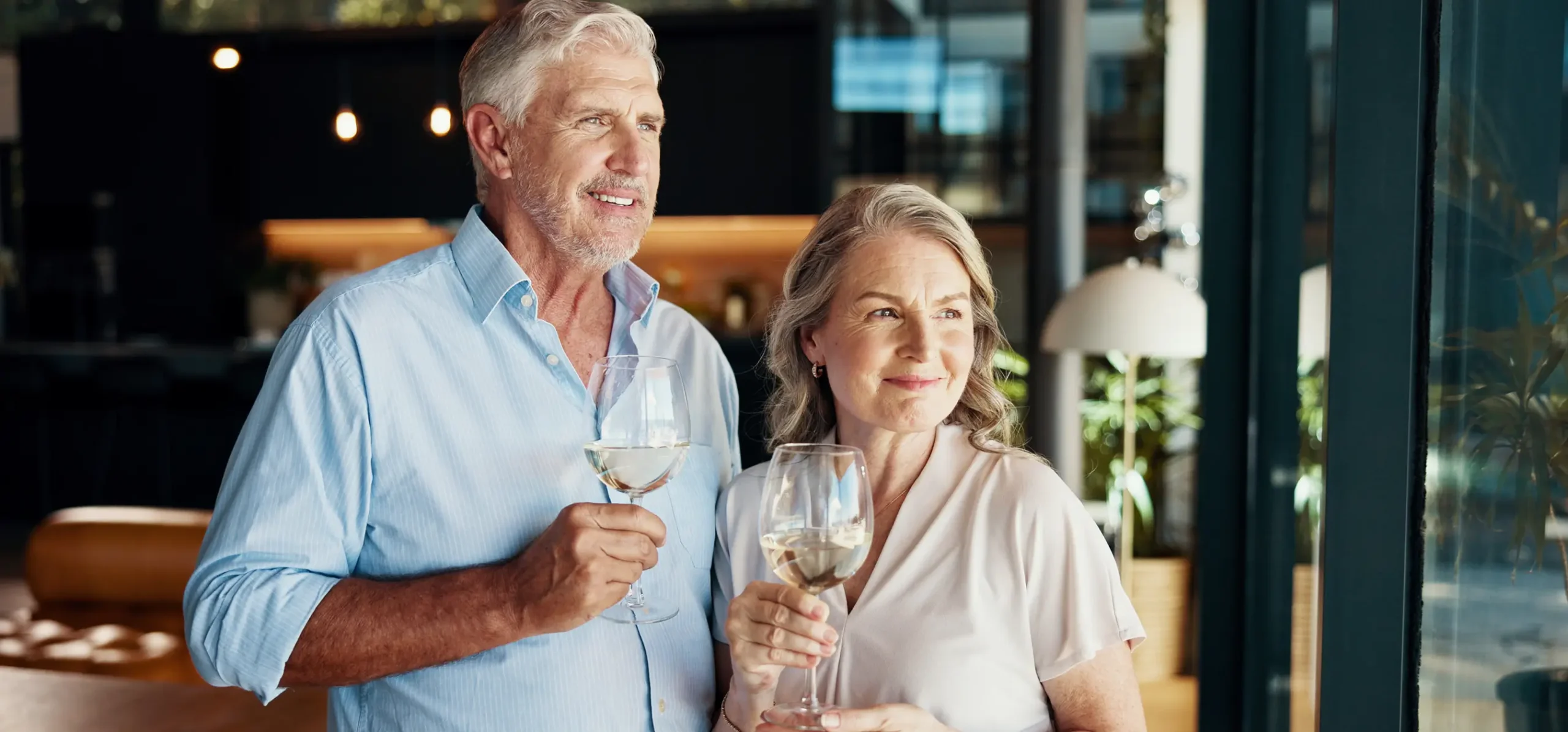 Elderly couple smiling with drinks in hand