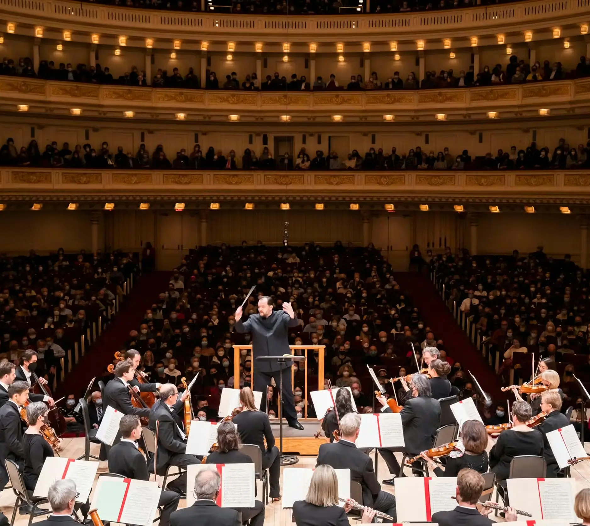 A full concert hall with an orchestra performing