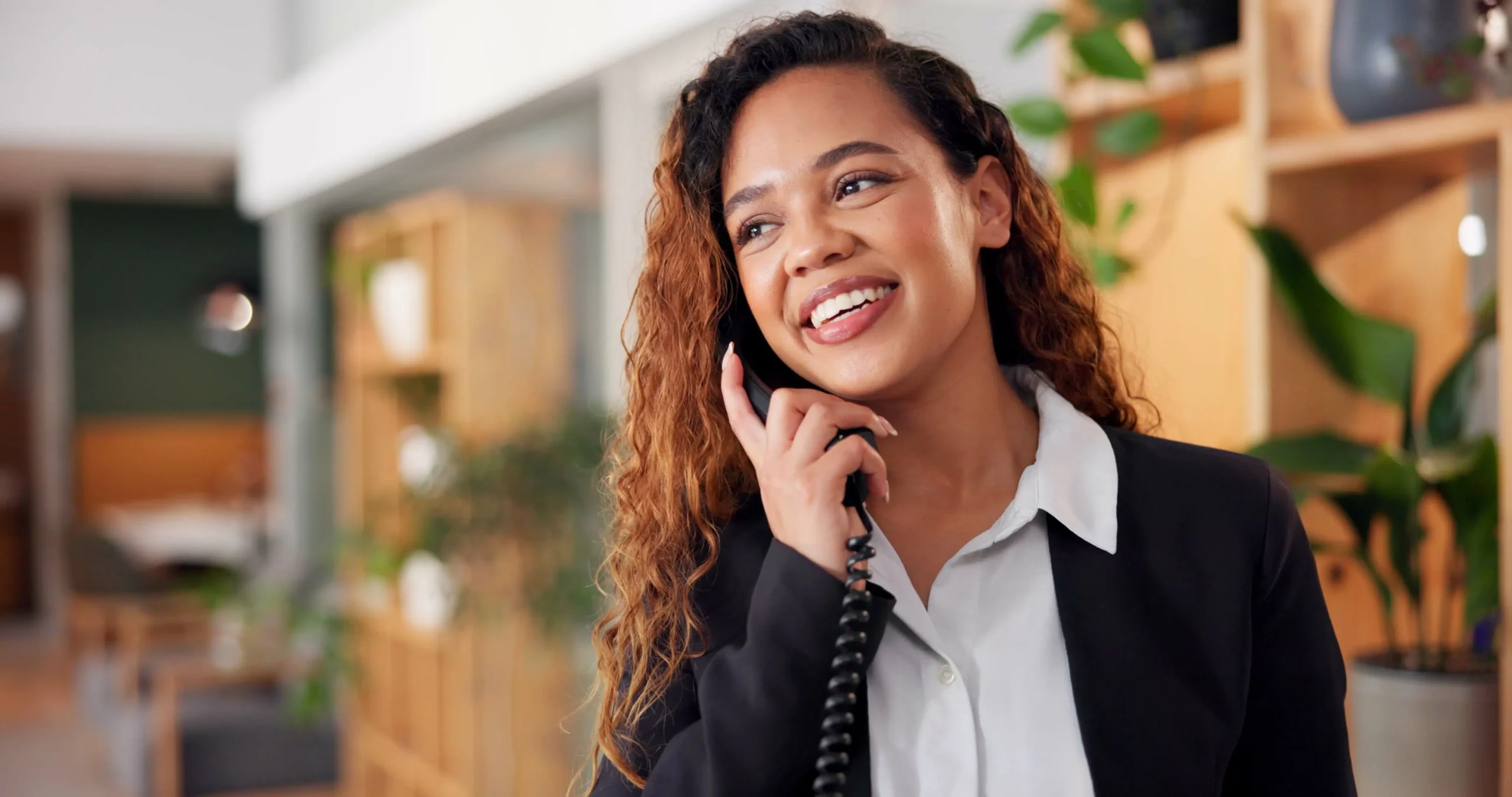 A staff member speaking on the phone in a facility's interior.