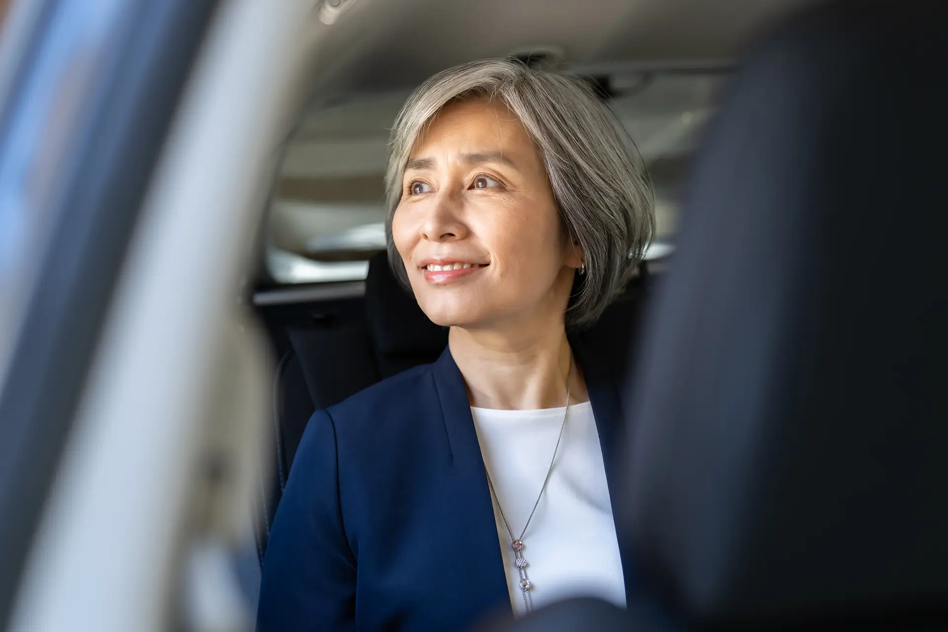 A senior woman smiling in a vehicle