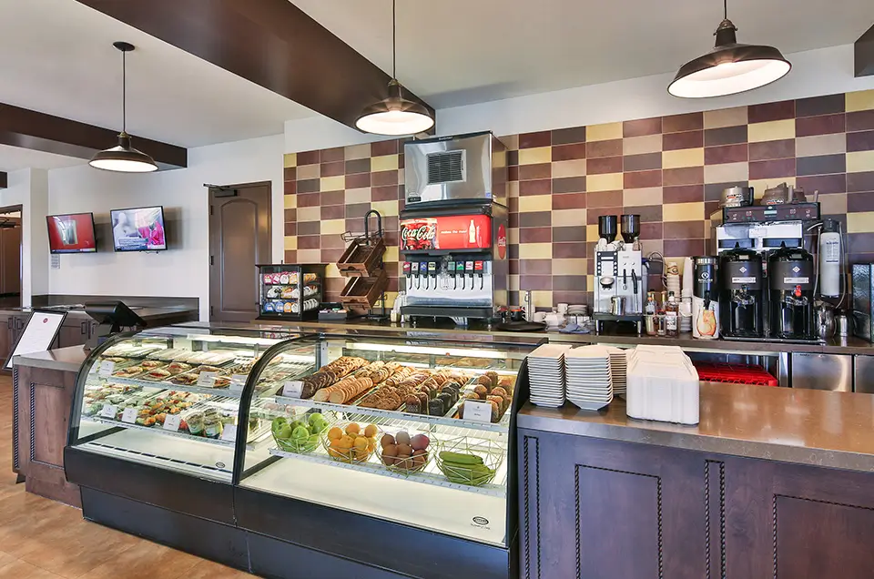 Brightly lit dining area with a glass display case of food