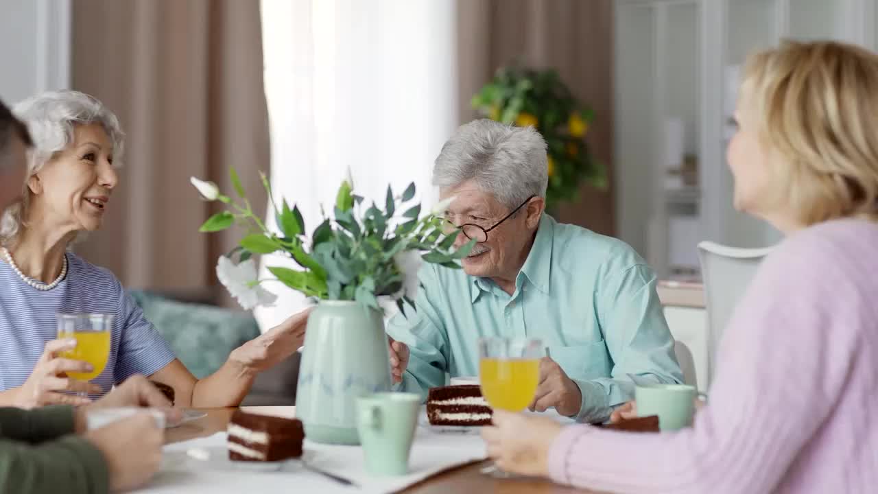 Residents enjoying cake and drinks in a lively dining room
