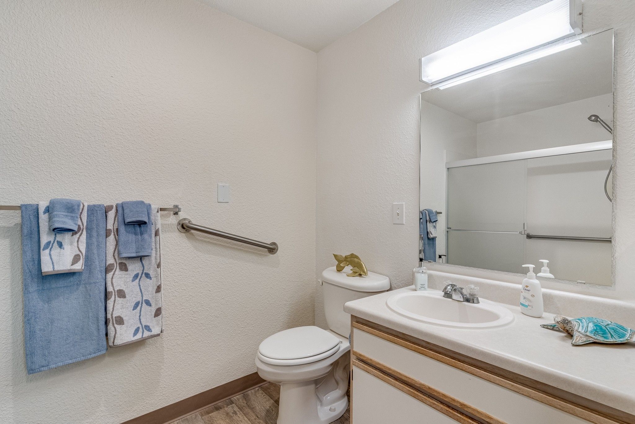 Well-lit bathroom with grab bars and towels
