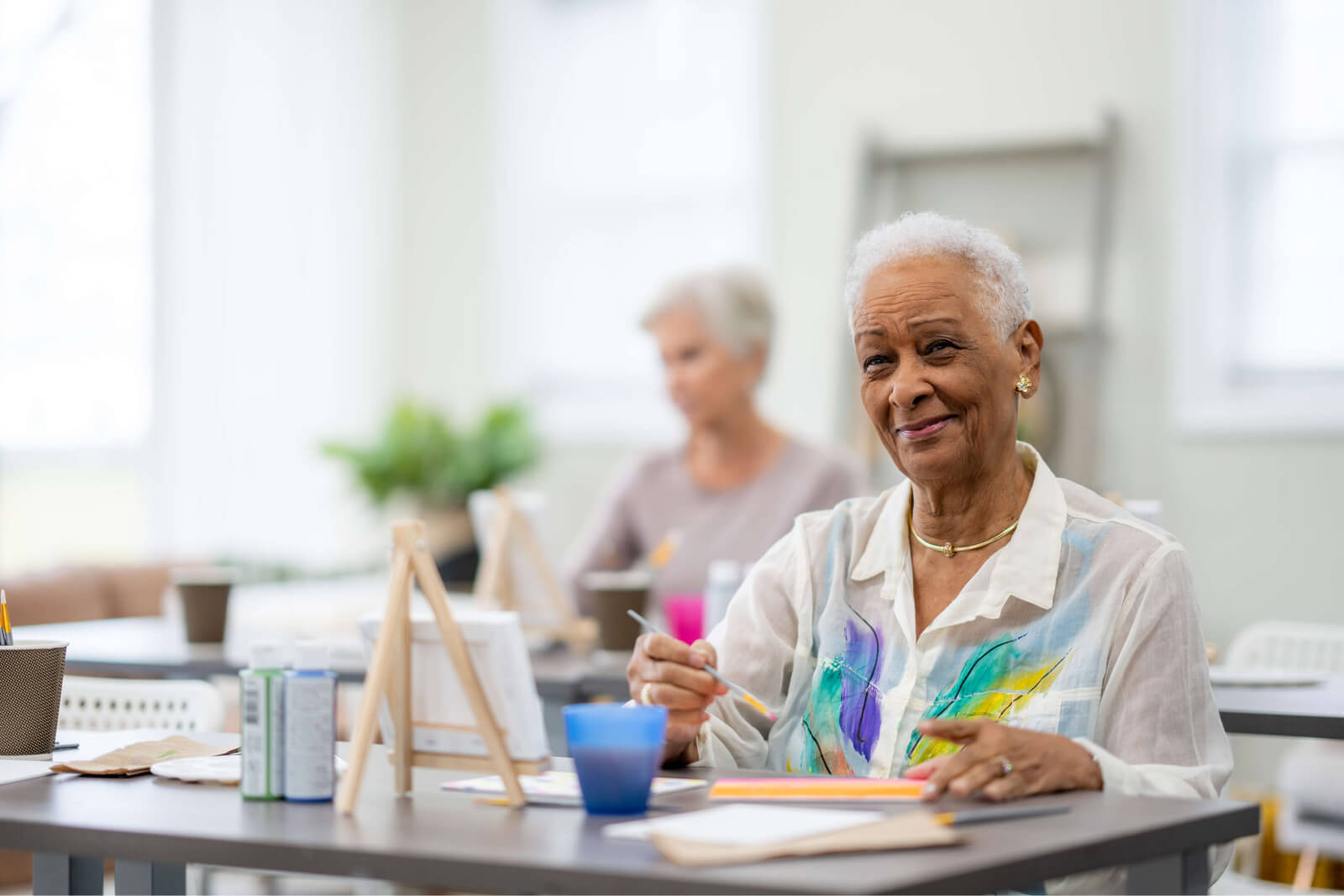Resident engaged in an art activity in a bright room