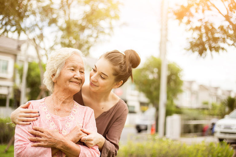 A caregiver and a resident enjoying time together in a garden