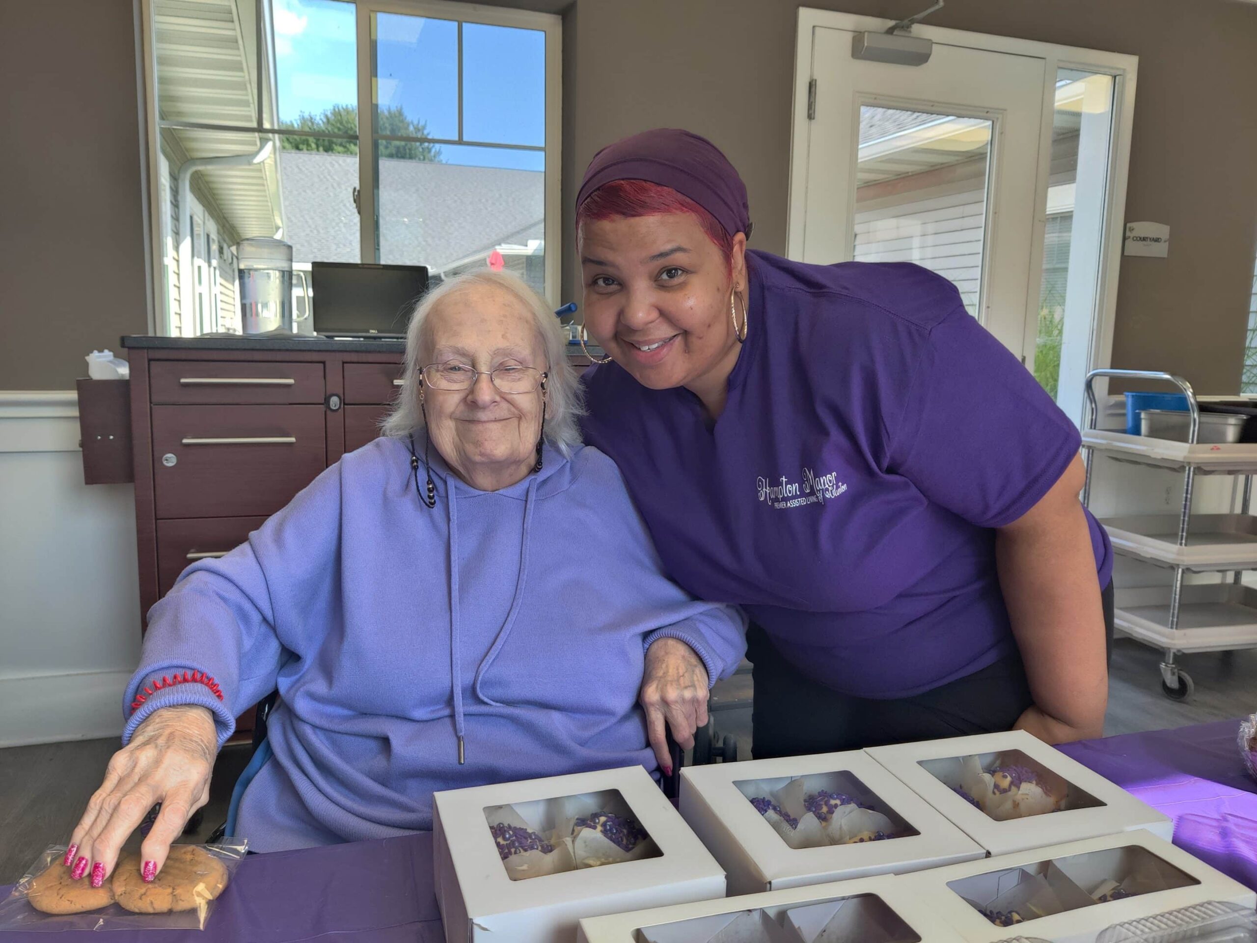 Resident and staff member smiling together in a common area