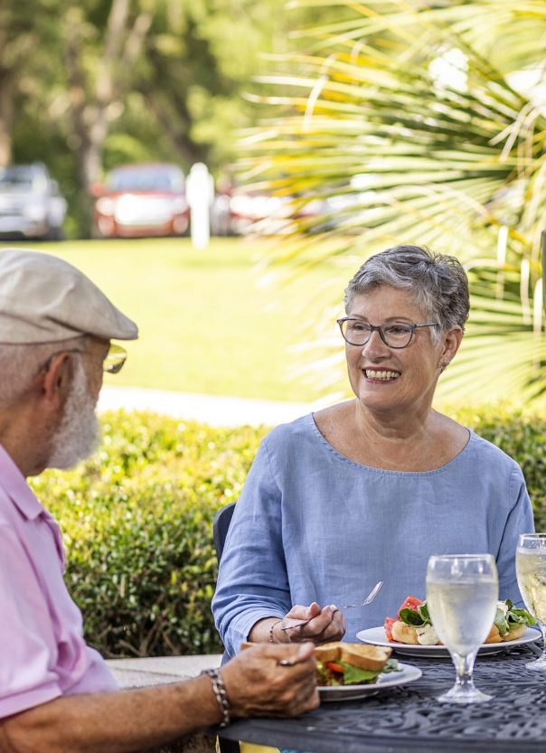 Two residents enjoying a meal outdoors in a garden setting
