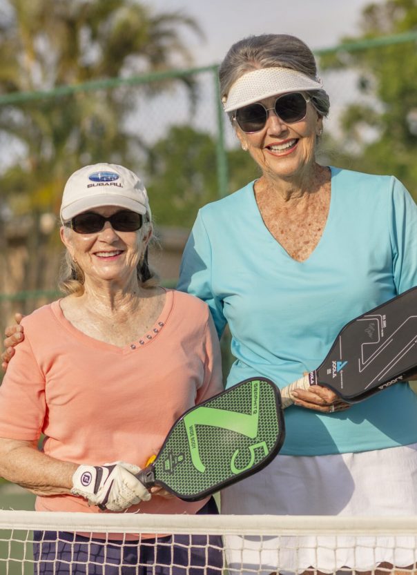 Two residents enjoying a game of pickleball outdoors