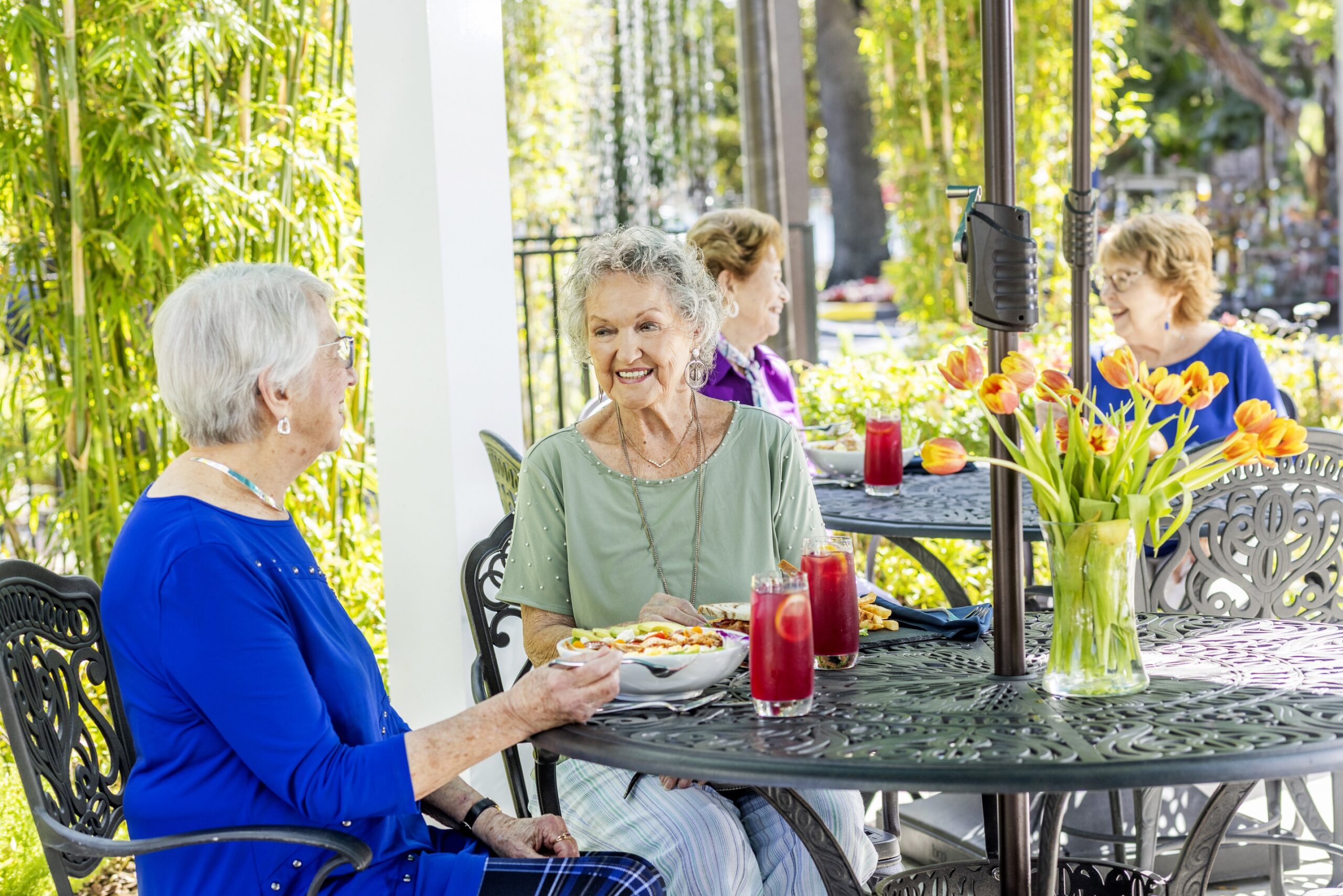 Residents enjoying a meal outdoors with flowers