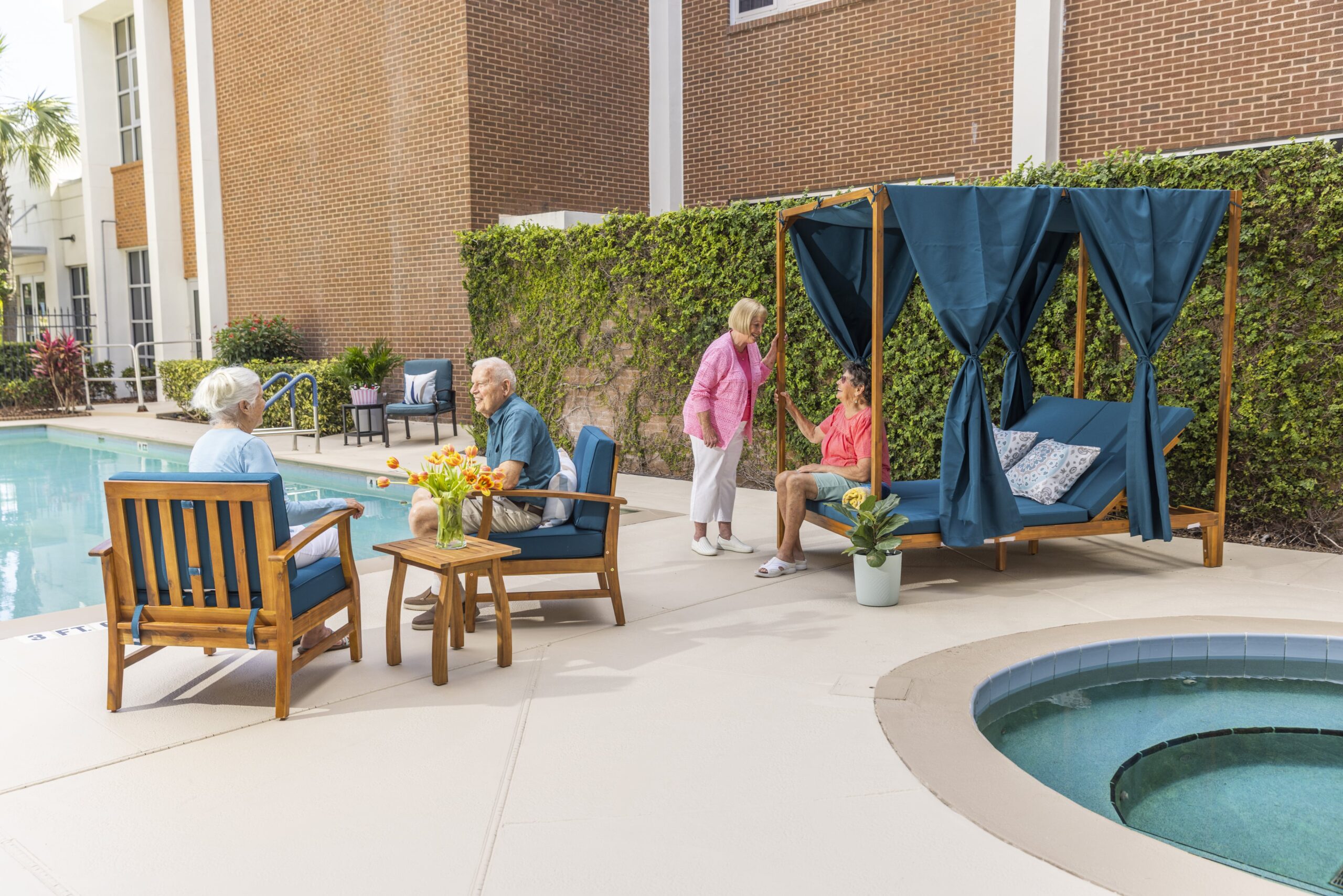 Residents enjoying a sunny afternoon by the pool