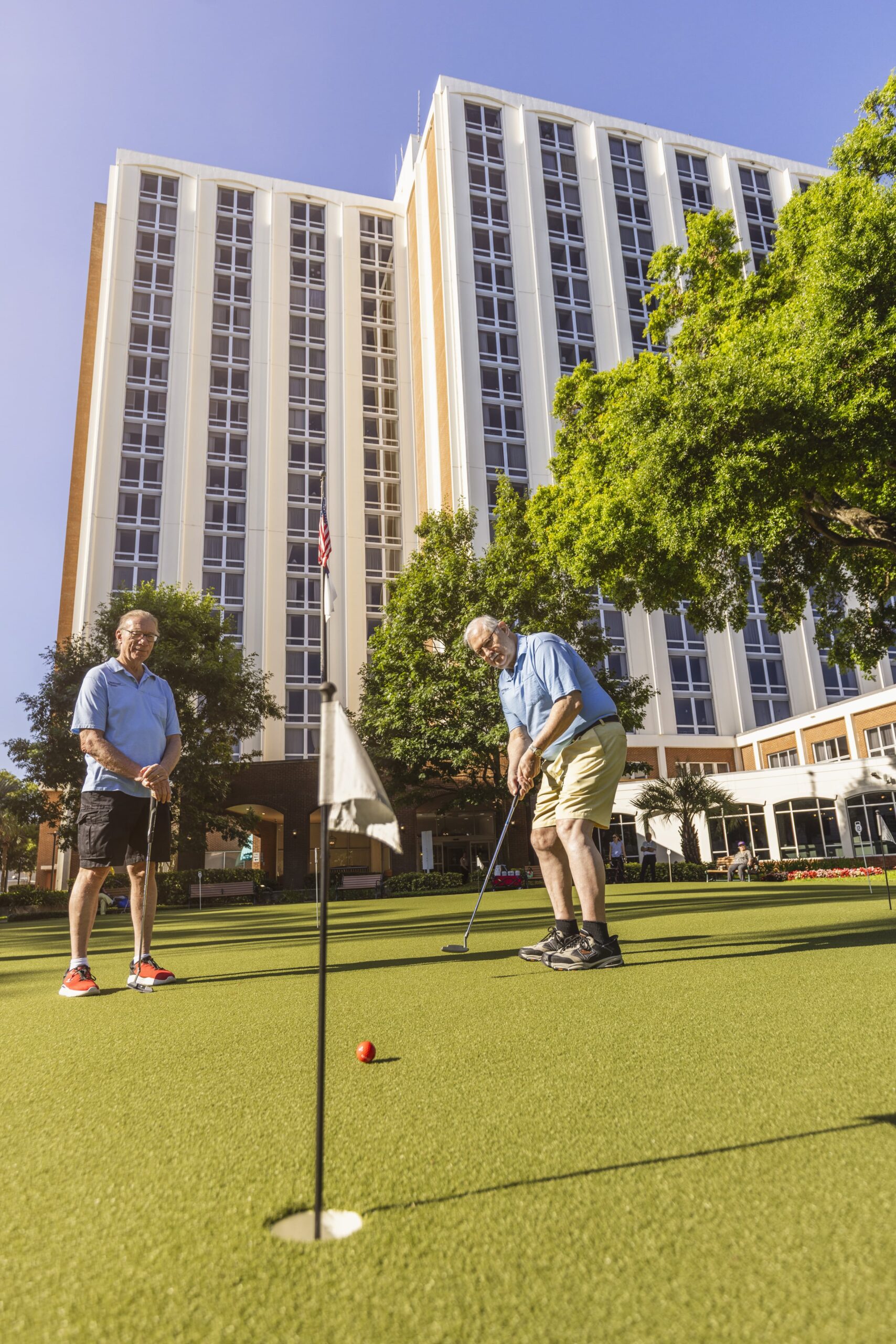 Residents playing golf on the lawn in front of the building