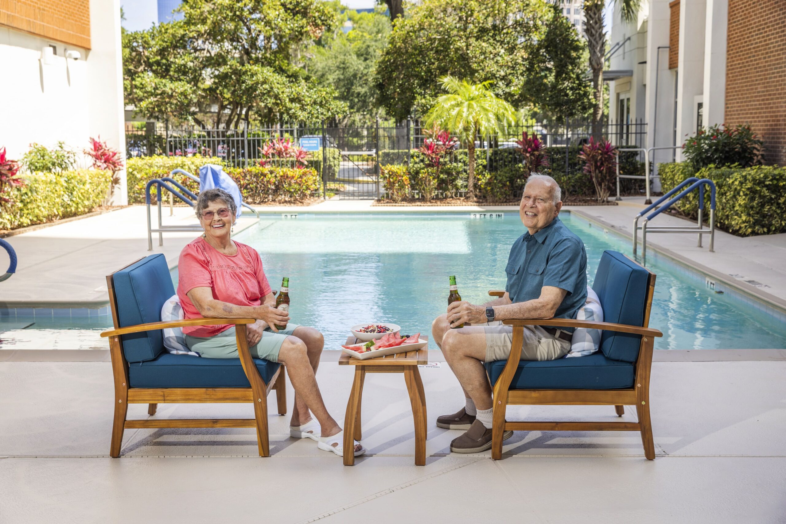 Two residents enjoying drinks by the poolside
