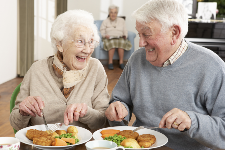 Two residents enjoying a meal together with smiles