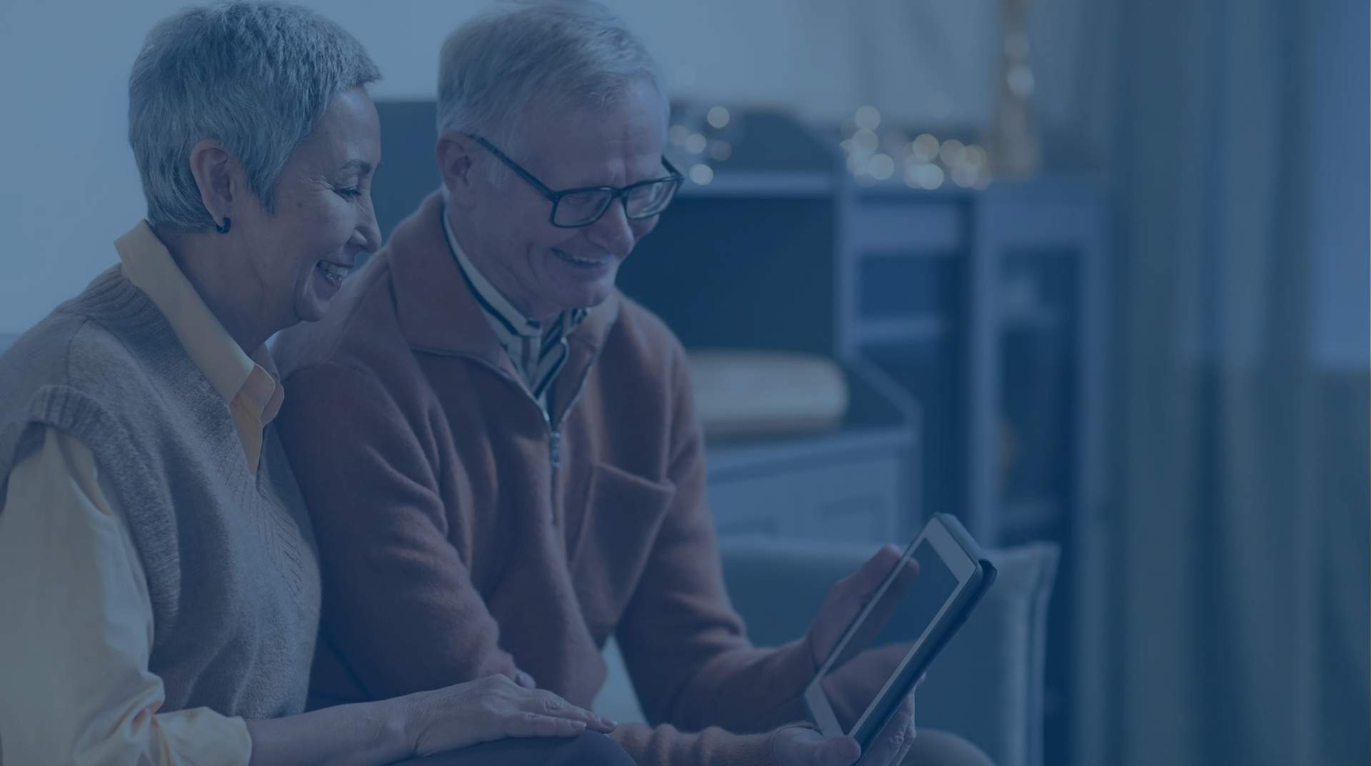 A senior couple using a tablet together in a cozy setting