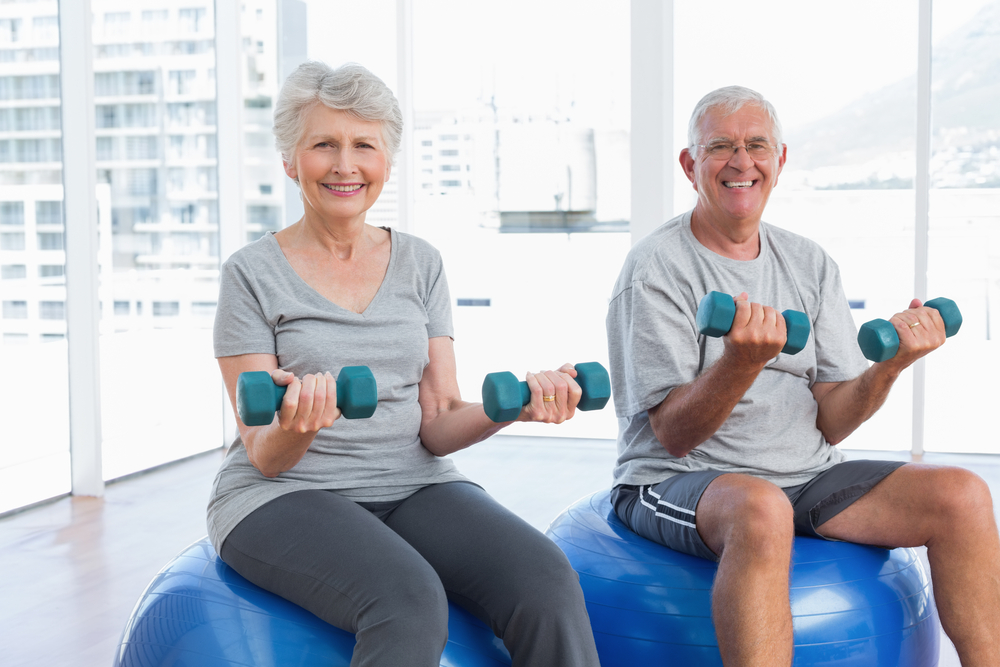 Seniors exercising with dumbbells in a fitness area