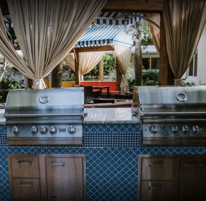 Outdoor grilling area with seating and canopy