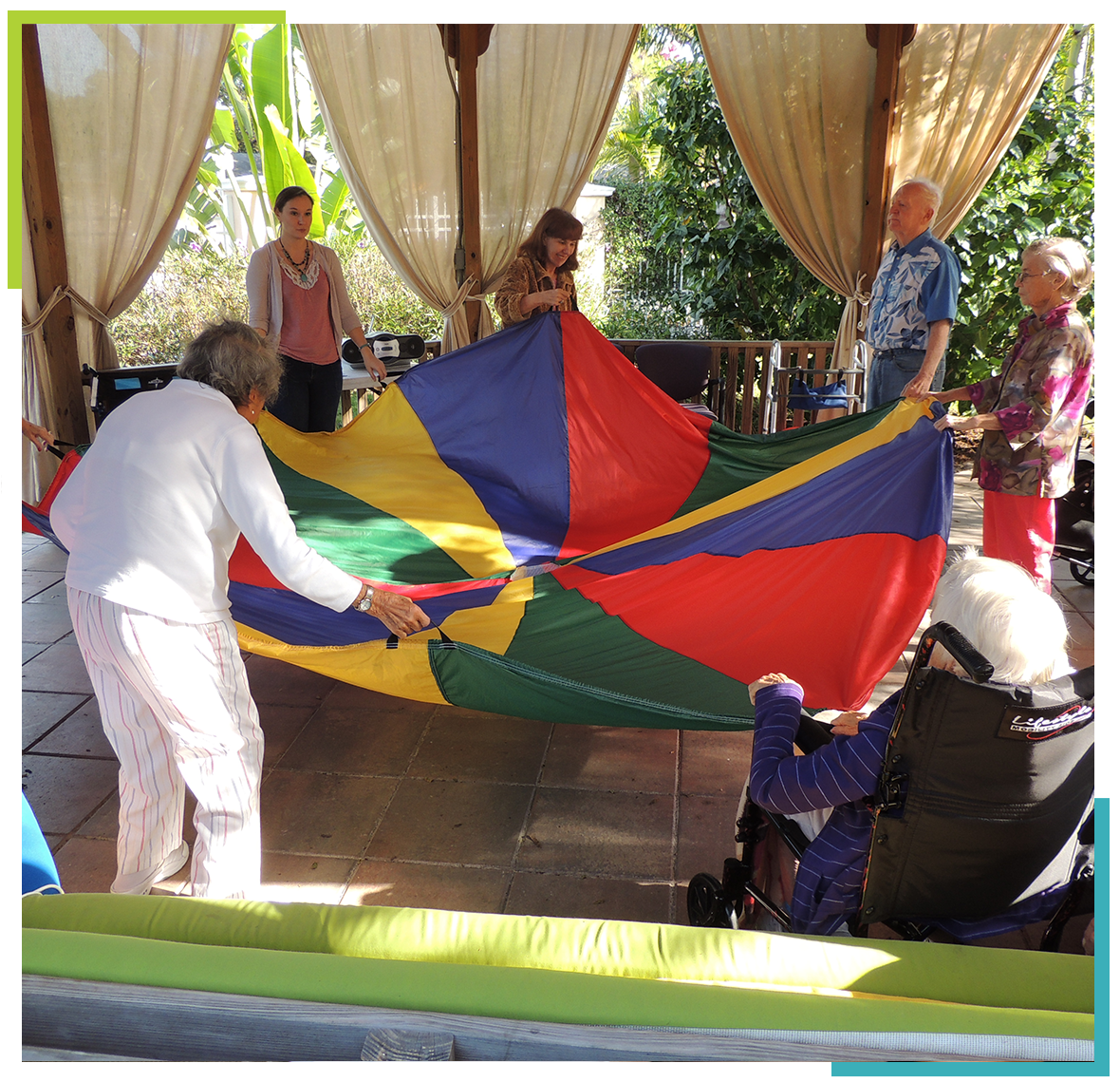 Residents and staff participating in a group activity with a colorful parachute