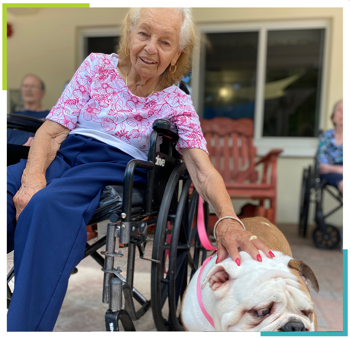 Resident in wheelchair petting a dog outdoors