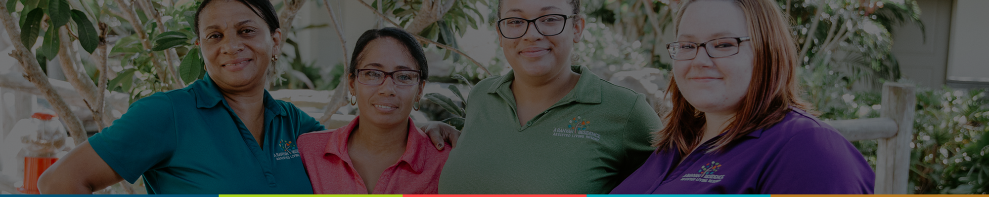 Staff members smiling in a garden setting