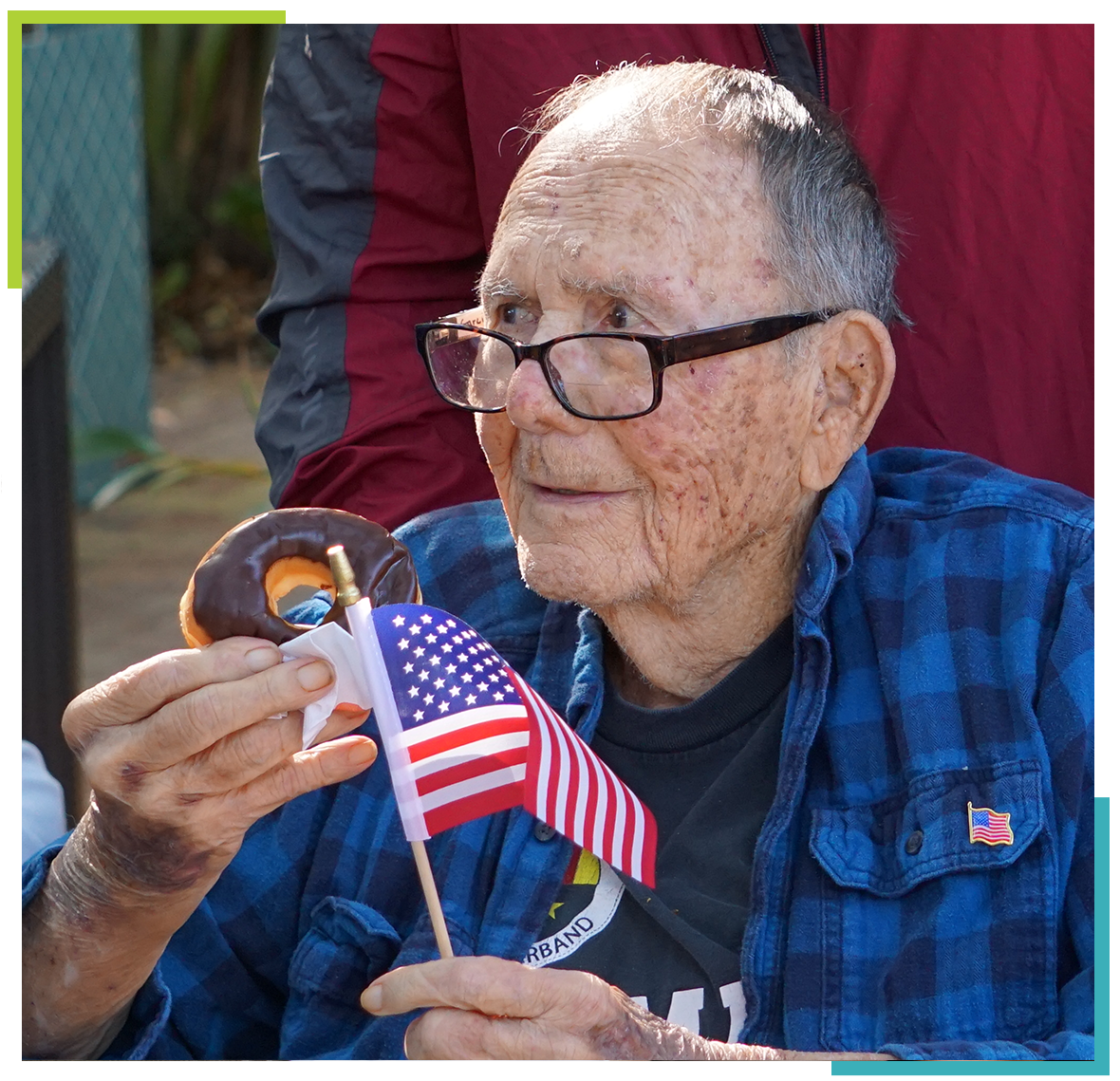 Elderly man enjoying a donut with an American flag