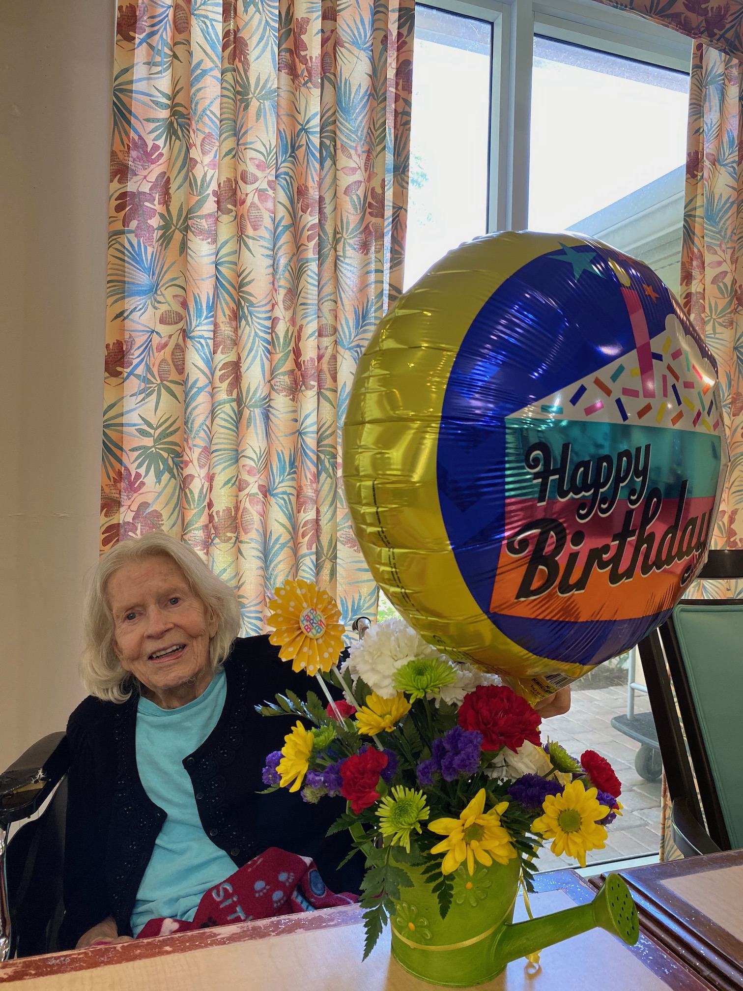 Resident celebrating birthday with balloon and flowers